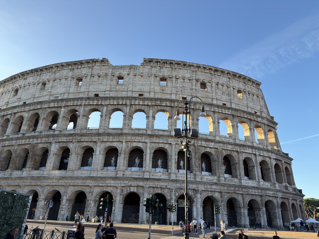 The Colosseum in Rome, Italy, showcasing its iconic architecture under a clear blue sky.